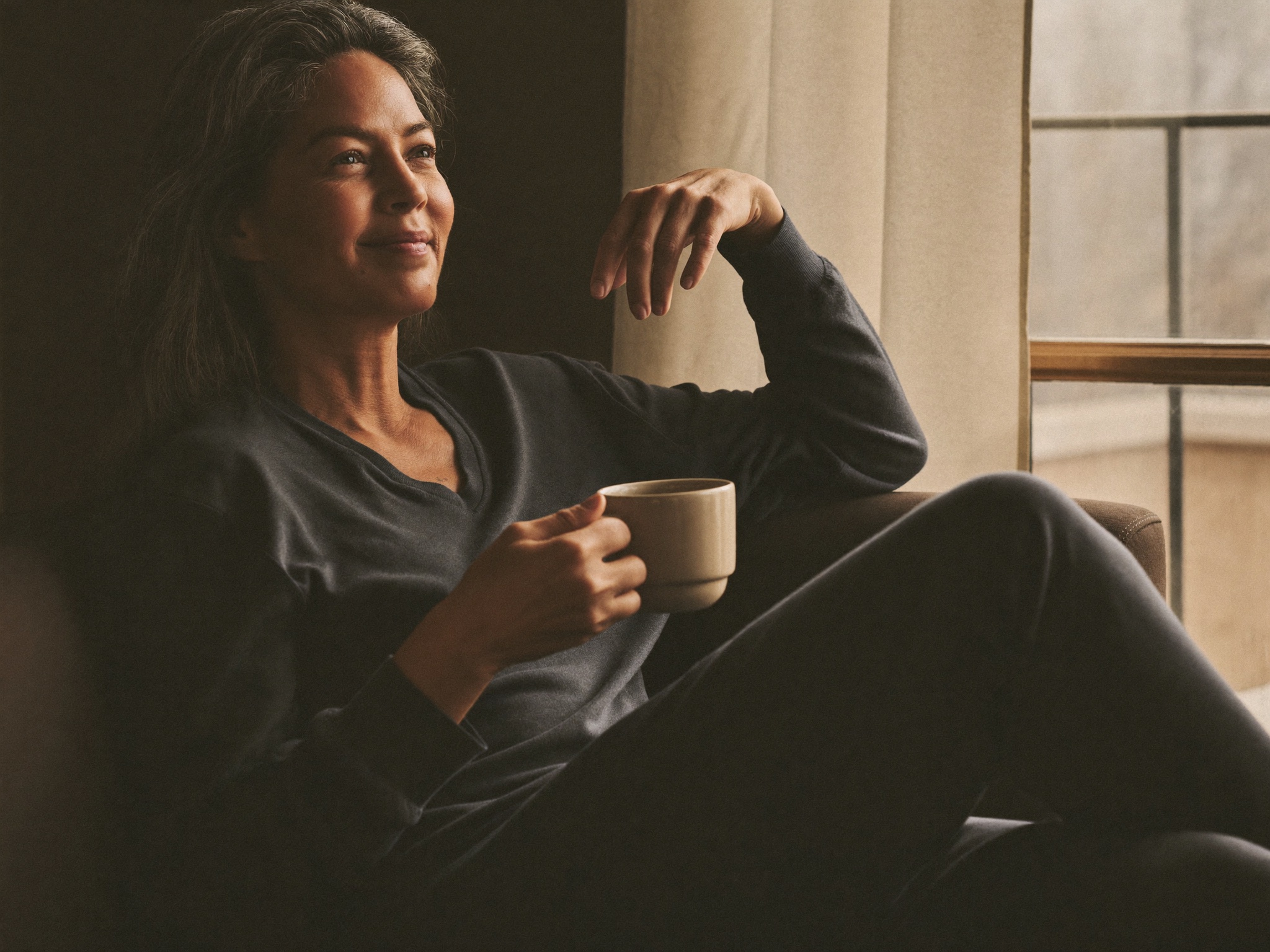 An adult resting comfortably at home during recovery, fully clothed, calm and reassured