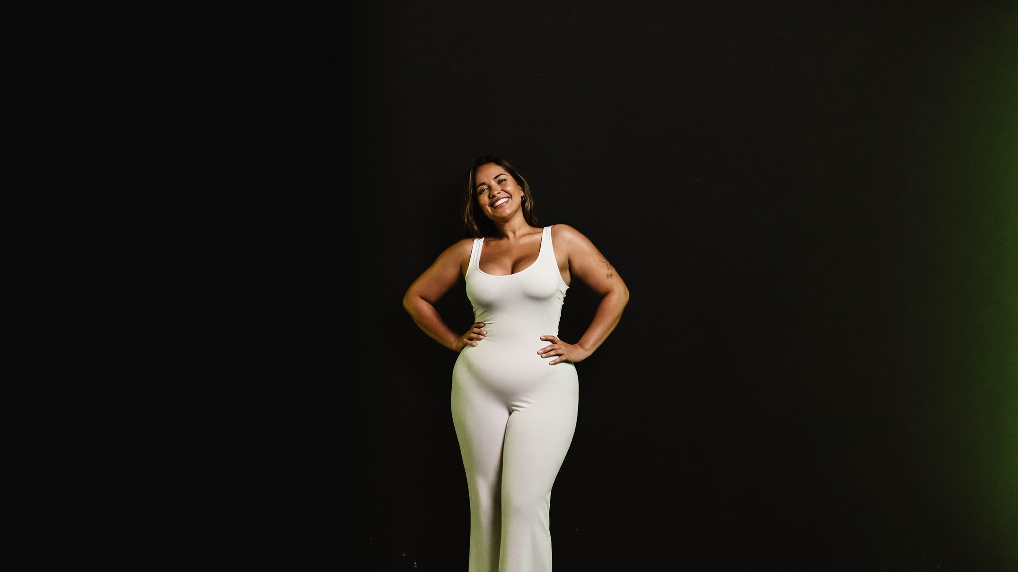 A joyful, confident adult in fitted everyday clothing after finishing a bariatric weight-loss and body-lift journey