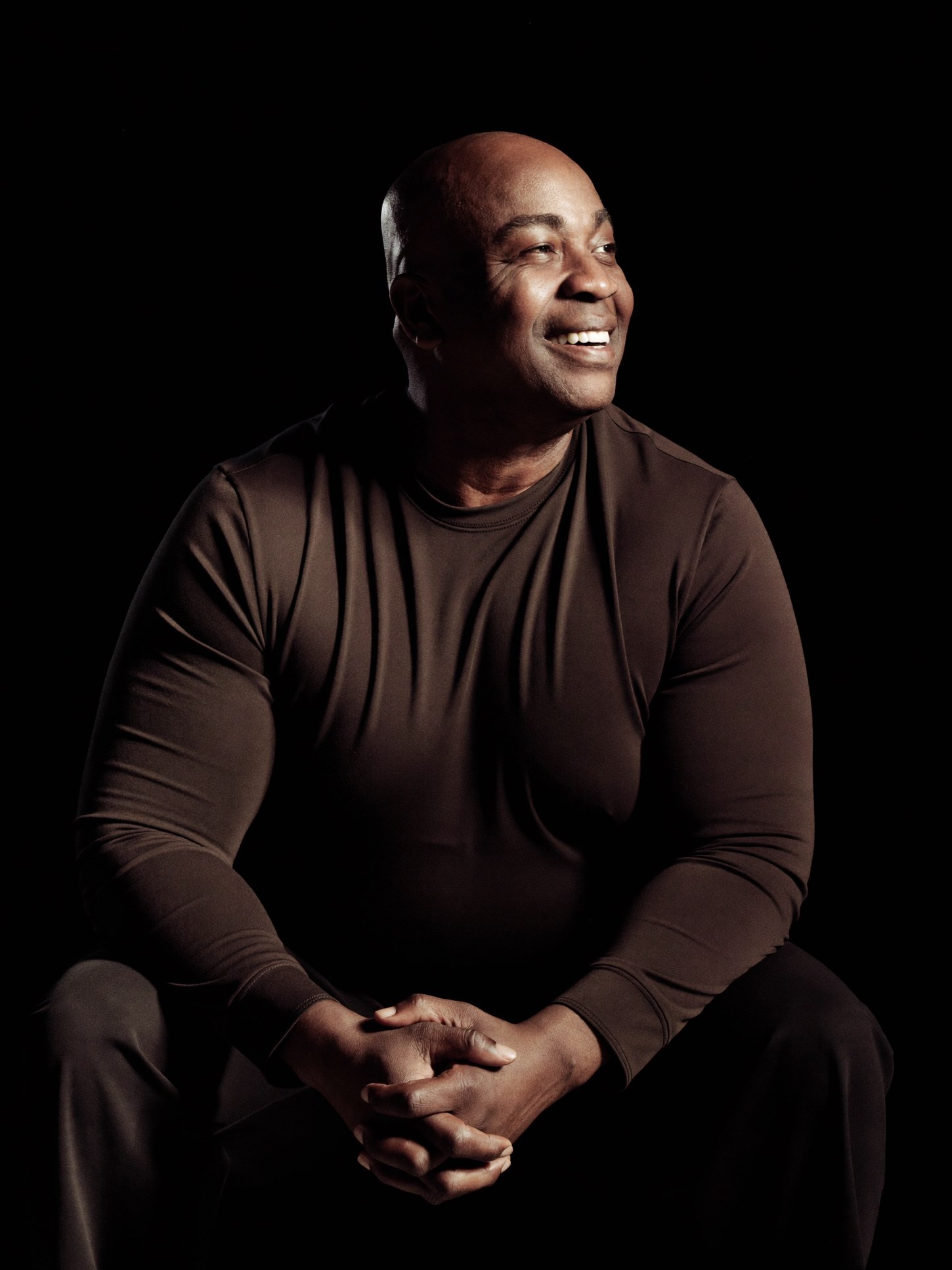 A confident person who completed a bariatric weight-loss and body-lift journey years ago, fully clothed, calm and proud