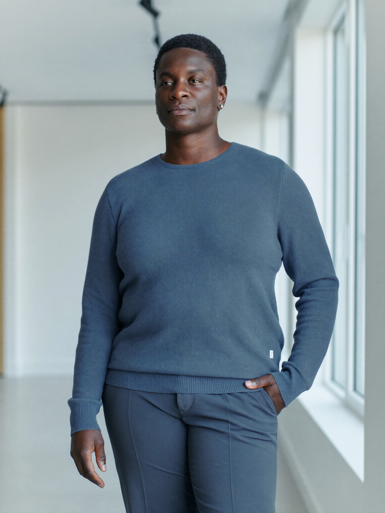 A confident adult at ease in a bright modern space, years after completing a major weight-loss journey